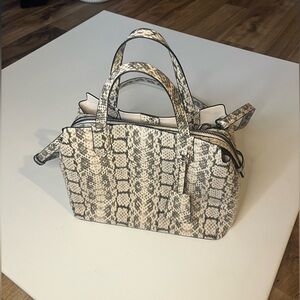 Snakeskin crossbody bag with multiple compartments.